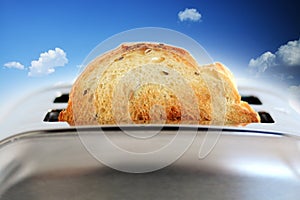 Composite image of roasted bread in silver toaster against blue sky