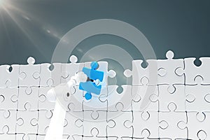 Composite image of robotic arm holding blue jigsaw piece by puzzle 3d