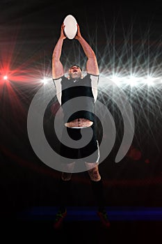 Composite image of rugby player catching the ball