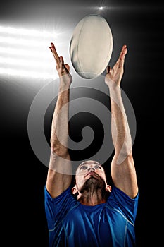 Composite image of rugby player catching ball