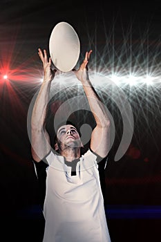 Composite image of rugby player catching the ball