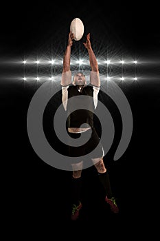 Composite image of rugby player catching the ball