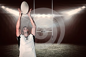 Composite image of rugby player catching the ball