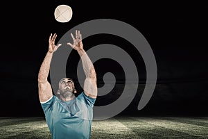 Composite image of rugby player catching the ball