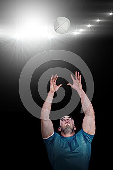 Composite image of rugby player catching the ball