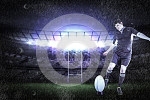 Composite image of rugby player doing a drop kick