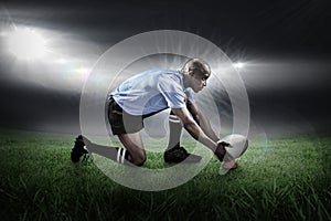 Composite image of rugby player keeping ball on kicking tee