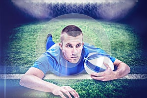 Composite image of rugby player looking away while lying in front with ball