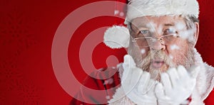 Composite image of santa claus blowing fake snow