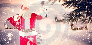 Composite image of santa claus holding a sack and bell