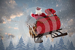 Composite image of santa claus riding on sled with gift box