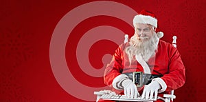 Composite image of santa claus typing on keyboard