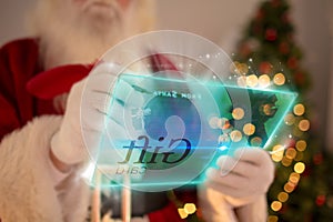 Composite image of santa using futuristic touchscreen