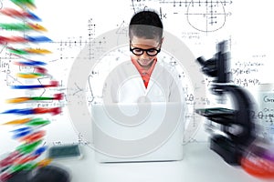 Composite image of schoolboy using laptop at desk