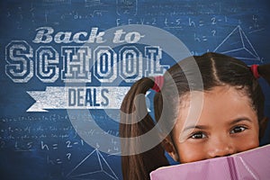 Composite image of schoolgirl covering mouth with book