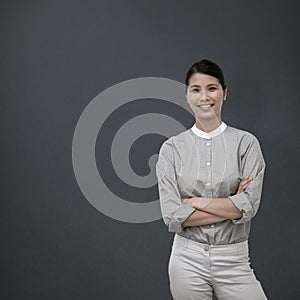 Composite image of selfassured businesswoman with folded arms