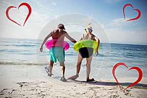 Composite image of senior couple on beach and hearts