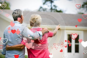 Composite image of senior couple before home and valentines hearts 3d