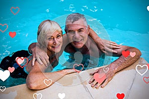 Composite image of senior couple in pool and valentines hearts 3d