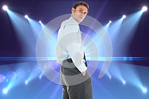 Composite image of serious businessman standing with hands in pockets