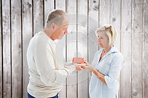 Composite image of serious mature couple with model house