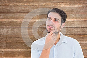 Composite image of serious thinking man looking up