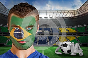 Composite image of serious young brasil fan with face paint