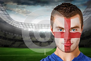 Composite image of serious young england fan with face paint