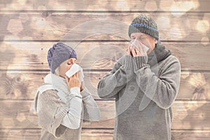 Composite image of sick mature couple blowing their noses