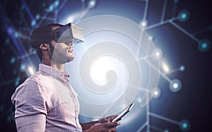 Composite image of side view of businessman holding virtual glasses and tablet computer