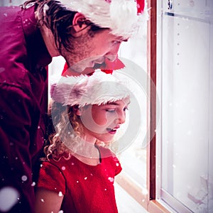 Composite image of side view of father and daughter in christmas attire looking at jewelry display