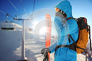 Composite image of skier talking on phone while holding skis