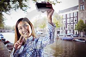 Composite image of smiling asian woman taking picture with camera