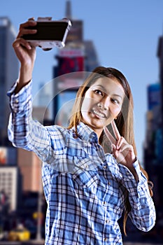 Composite image of smiling asian woman taking picture with camera