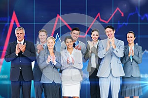 Composite image of smiling business team applauding at camera