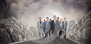 Composite image of smiling business team looking at camera
