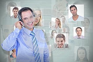 Composite image of smiling businessman using headset