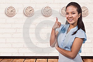 Composite image of smiling businesswoman with thumbs up