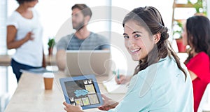 Composite image of smiling businesswoman using tablet