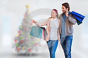 Composite image of smiling couple walking hand in hand and going window shopping