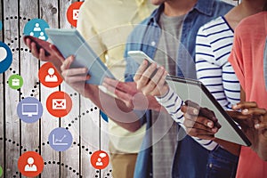 Composite image of smiling creative team standing in a line using technology