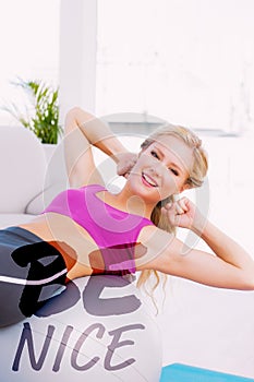 A Composite image of smiling fit blonde doing sit ups with exercise ball