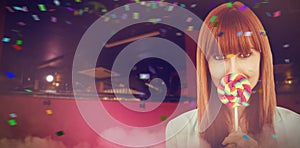 Composite image of smiling hipster woman with a lollipop