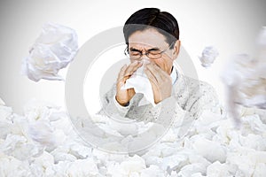 Composite image of smiling man using a tissue