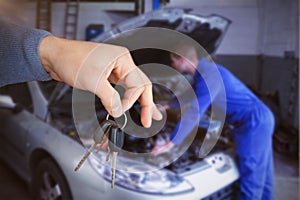 Composite image of smiling woman receiving keys from somebody