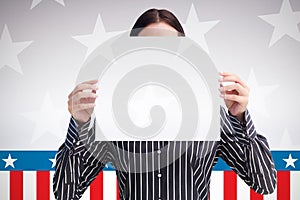 Composite image of smiling woman showing a big business card in front of her face