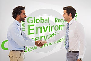 Composite image of smiling young businessmen shaking hands in office