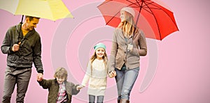 Composite image of smiling young family under umbrella