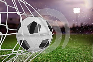 Composite image of soccer ball in goal net