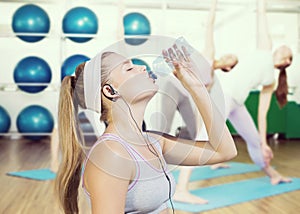 Composite image of sporty blonde drinking water